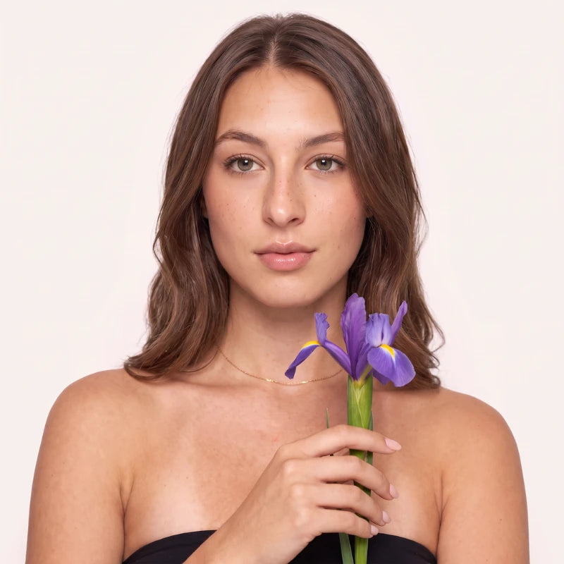 Modelo segurando flor de Íris, inspiração do design dos cílios magnéticos Cortezzo Camélia