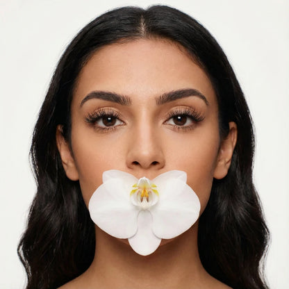 Mulher segurando orquídea usando cílios magnéticos Cortezzo